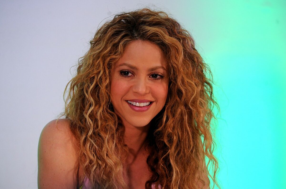 Shakira, la un eveniment, pe un fundal gri, cu părul desfăcut