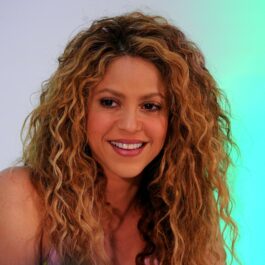 Shakira, la un eveniment, pe un fundal gri, cu părul desfăcut