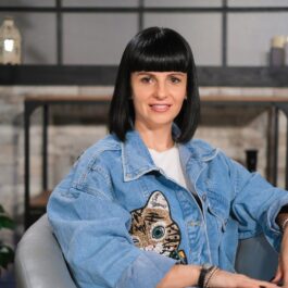 Simona Pungă, pe un fotoliu gri, într-un platou de filmare, la interviul CaTine.ro