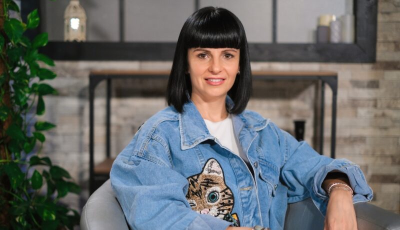 Simona Pungă, pe un fotoliu gri, într-un platou de filmare, la interviul CaTine.ro