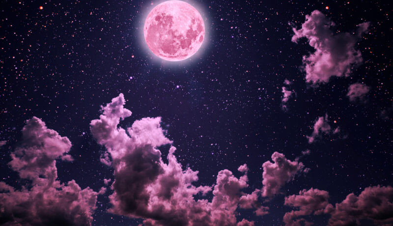 Superluna Roz pe cer negru cu nori roz și negri