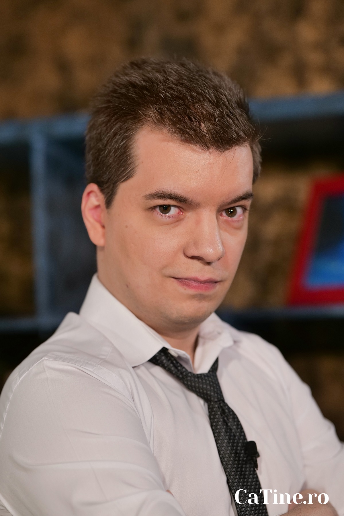 Toma Alexandru într-o cămașă albă cu o cravată neagră în timp ce pozează pentru interviul CaTine.ro