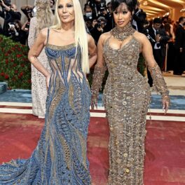 Donatella Versace într-o rochie albastră alături de Cardi Bi într-o rochie aurie cu paete în timp ce pozează pe covorul roșu de la Mat Gala 2022