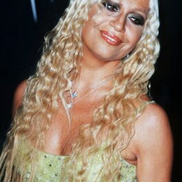 Donatella Versace, cu părul creț, într-o rochie cu corset, la o petrecere Versace în 1999