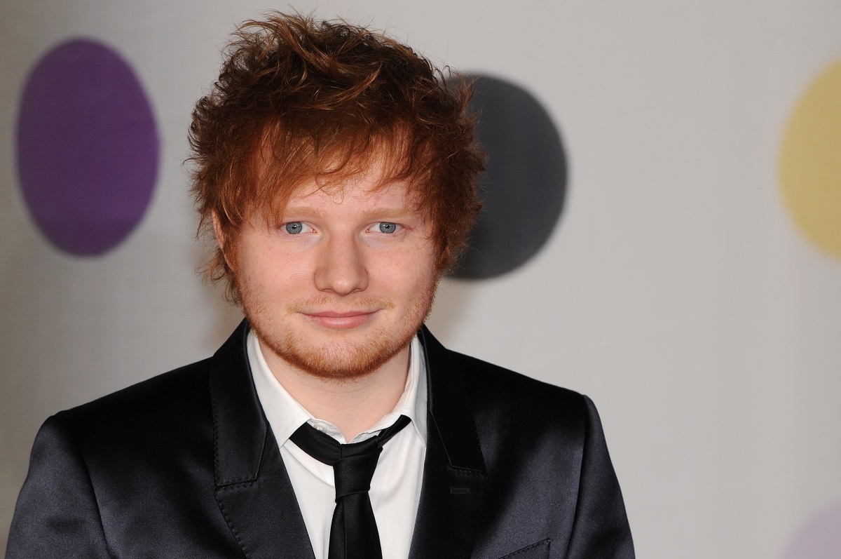 Ed Sheeran îmbrăcat la costum în timp ce participă la BRIT Awards în anul 2013