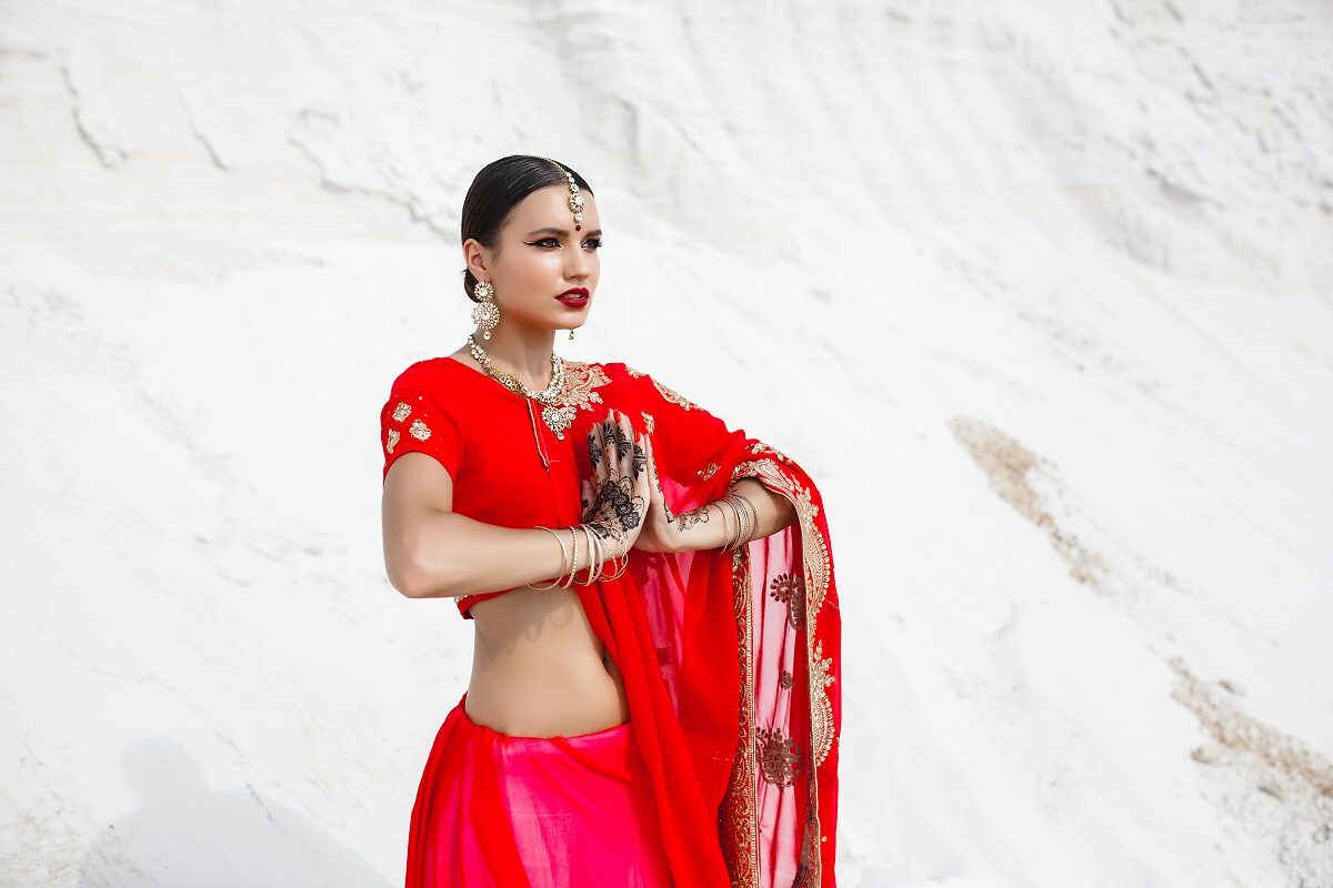 O femeie frumoasă care poartă o rochie roșie tradițională din portul indian pentru a reprezenenta horoscpul indian