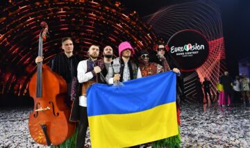 Kalush Orchestra în timp ce țin steagul Ucrainei pe scena Eurovision 2022