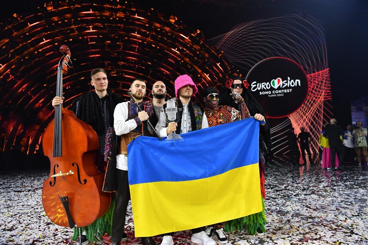 Kalush Orchestra în timp ce țin steagul Ucrainei pe scena Eurovision 2022