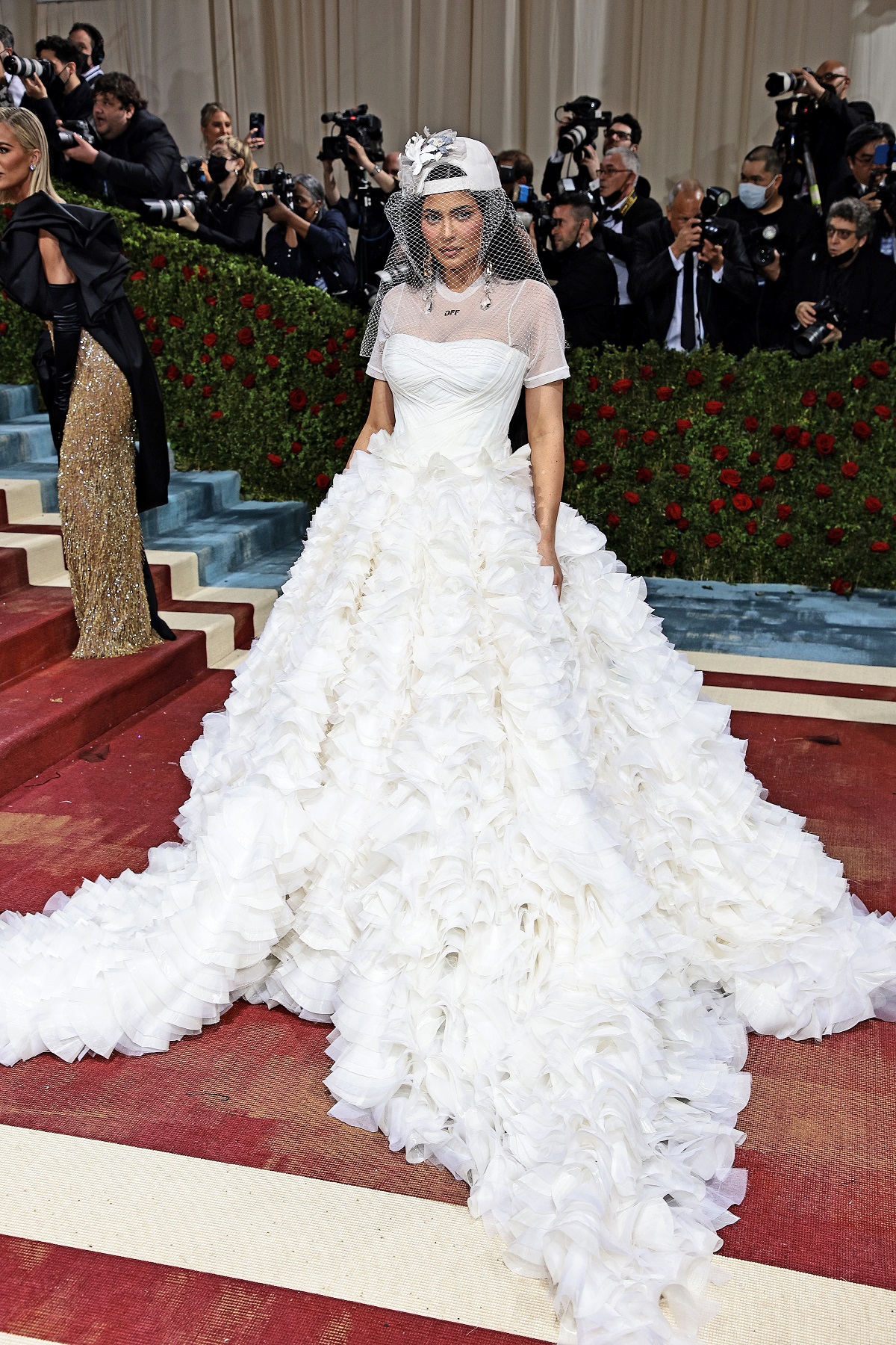 Kylie Jenner într-o rochie de miereasă albă în timp ce pozează pe covorul roșu de la Mat Gala 2022