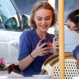 Lily Rose Depp într-un tricou albastru în timp ce ia masa în oraș cu o prietenă în 2012