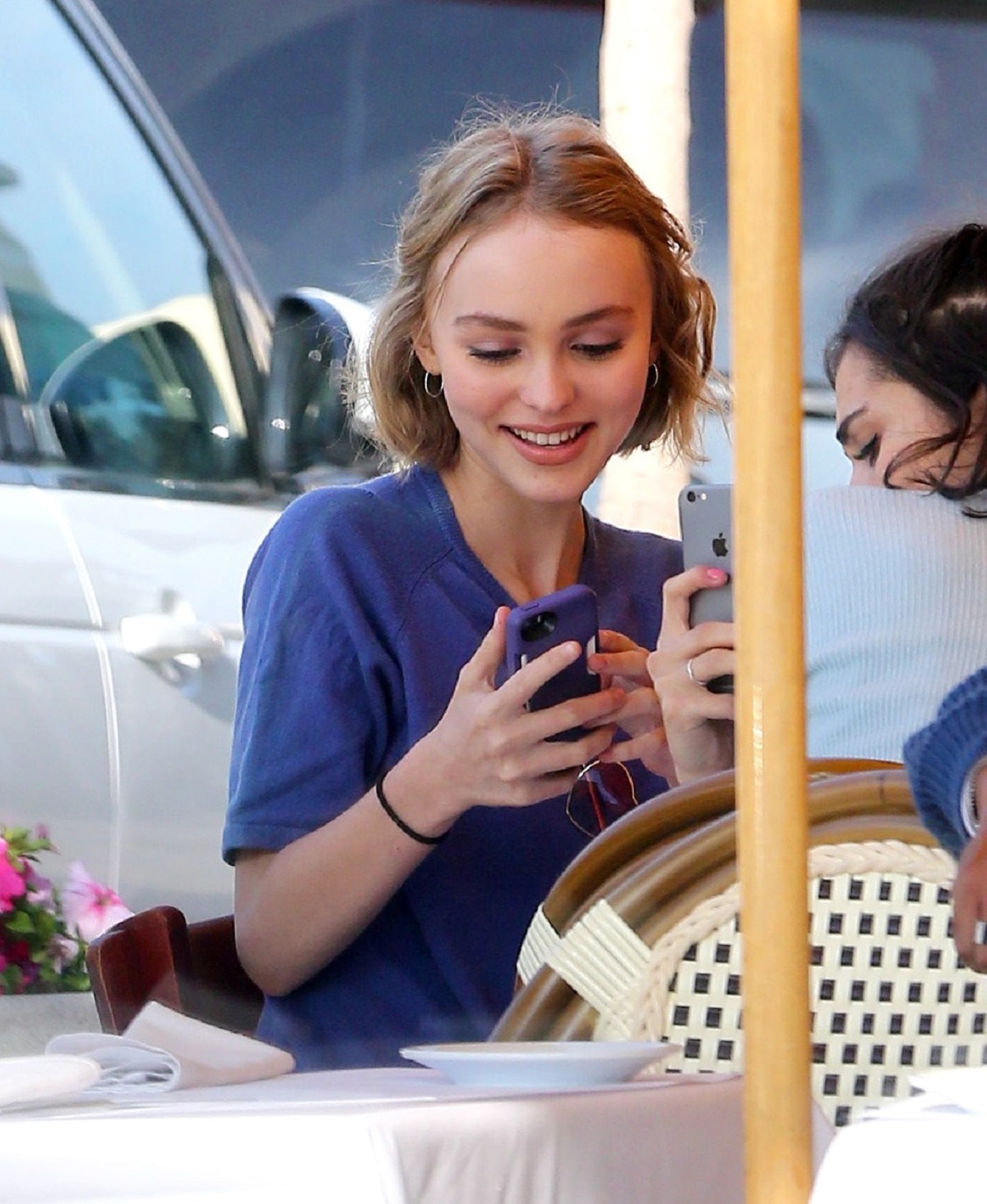 Lily Rose Depp într-un tricou albastru în timp ce ia masa în oraș cu o prietenă în 2012
