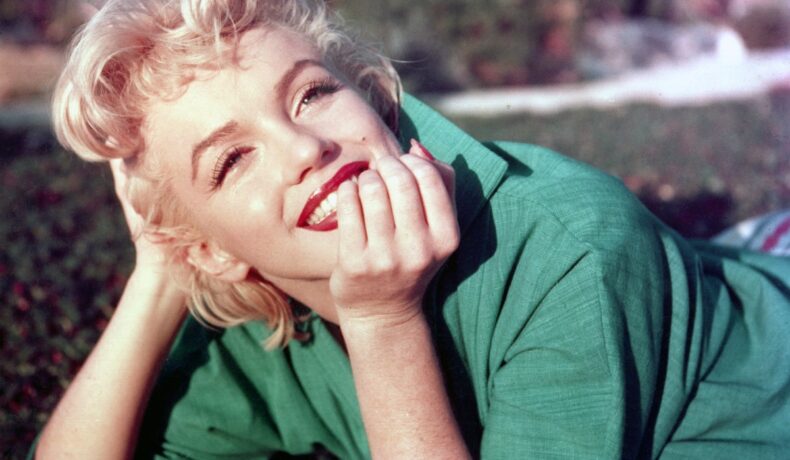 Marilyn Monroe într-o cămașă verde în timp ce pozează pentru un shooting foto