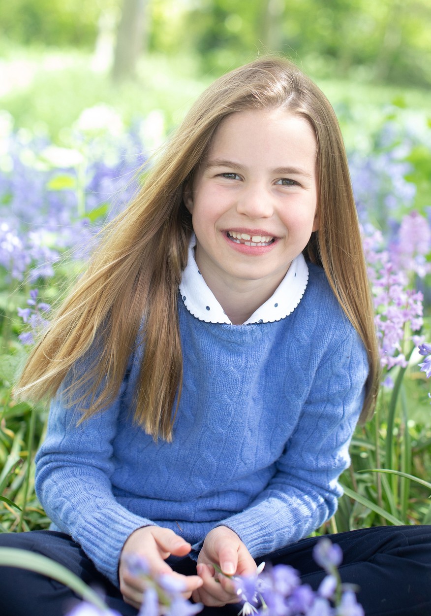 Prințesa Charlotte, în haine lejere, albastre, cu părul desfăcut, jucându-se în iarbă