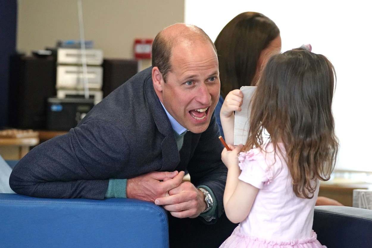 Prințul William, discută cu o fetiță într-un campus din Scoția