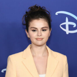 Selena Gomez, cu părul prins, îmbrăcată în haine deschise la culoare, la o emisiune TV