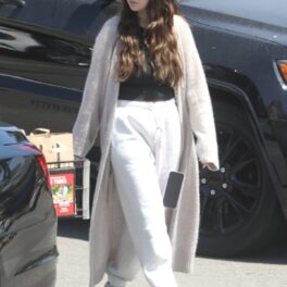 Selena Gomez într-o pereche de pantaloni albi și un tricou negru peste care a asortat un cardigan crem în timp ce s-a plimbat pe străzile din Malbu