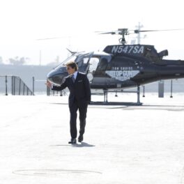 Tom Cruise în timp ce coboară dintr-un elicopter la premiera Top Gun 2