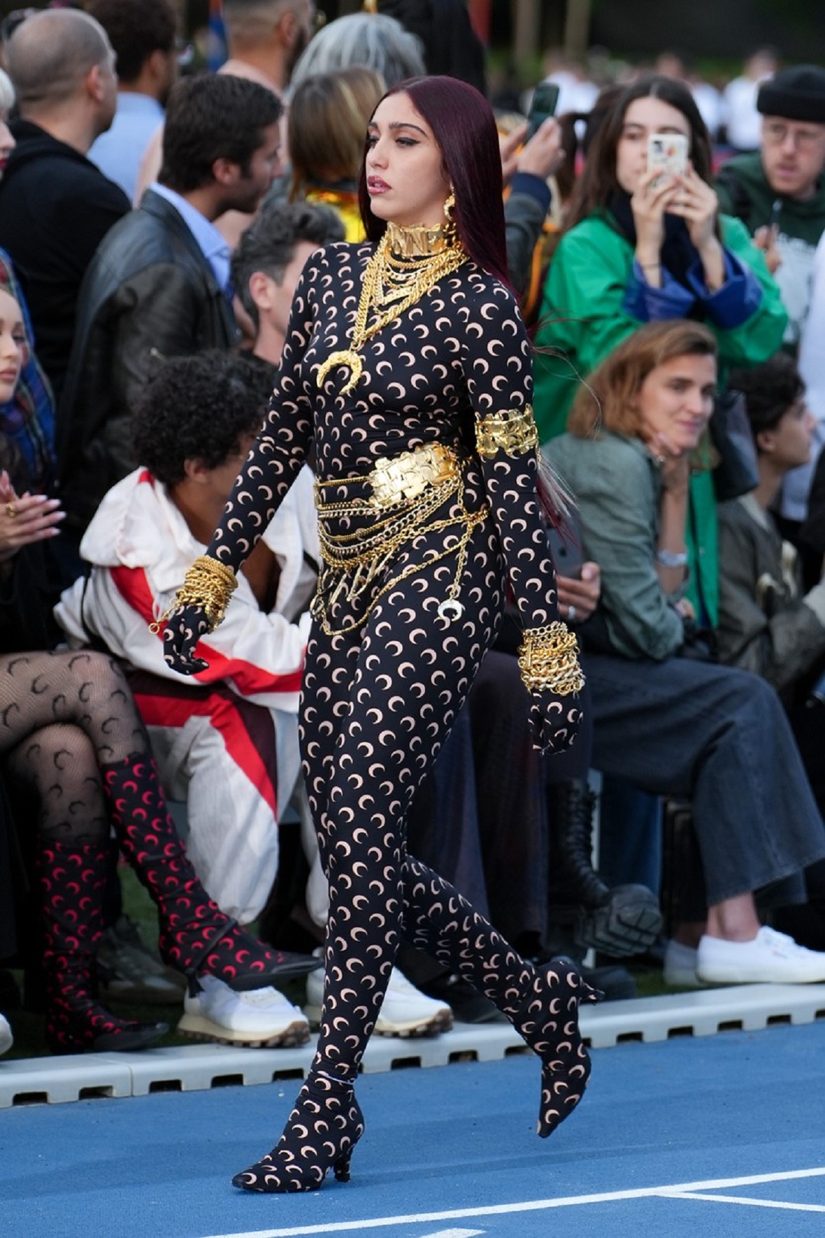 Lourdes Leon într-un costum negru mulat cu semilună aurie în timp ce defileză la un show de modă din Paris