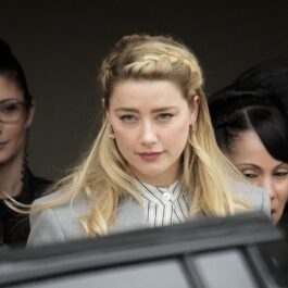 Amber Heard într-un costum gri în timp ce iese de la tribunal după procesul avut cu fostul său soț, Johnny Depp