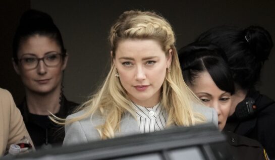 Amber Heard într-un costum gri în timp ce iese de la tribunal după procesul avut cu fostul său soț, Johnny Depp