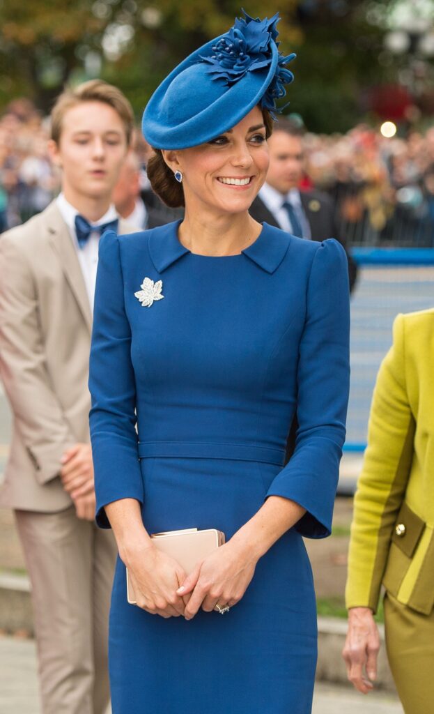 Potret cu Ducesa de Cambridge într-o ținută albastră în timp ce poartă una din pălăriile purtate de Kate Middleton la o vizită oficială din Canada în 2016