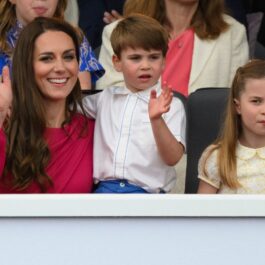 Kate Middleton în timp ce îl ține în brațe pe Prințul Louis care stă alături de Prințesa Charlotte