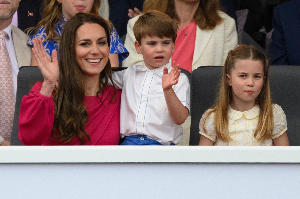 Kate Middleton în timp ce îl ține în brațe pe Prințul Louis care stă alături de Prințesa Charlotte