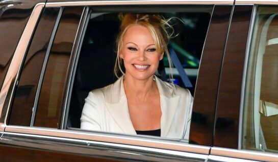 Pamela Anderson într-un sacou alb în tmp ce părăsește Ambassador Theatre după ce a jucat în musicalul Chicago