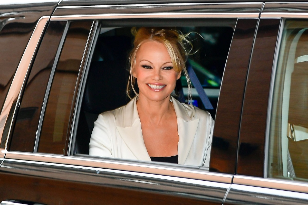 Pamela Anderson într-un sacou alb în tmp ce părăsește Ambassador Theatre după ce a jucat în musicalul Chicago