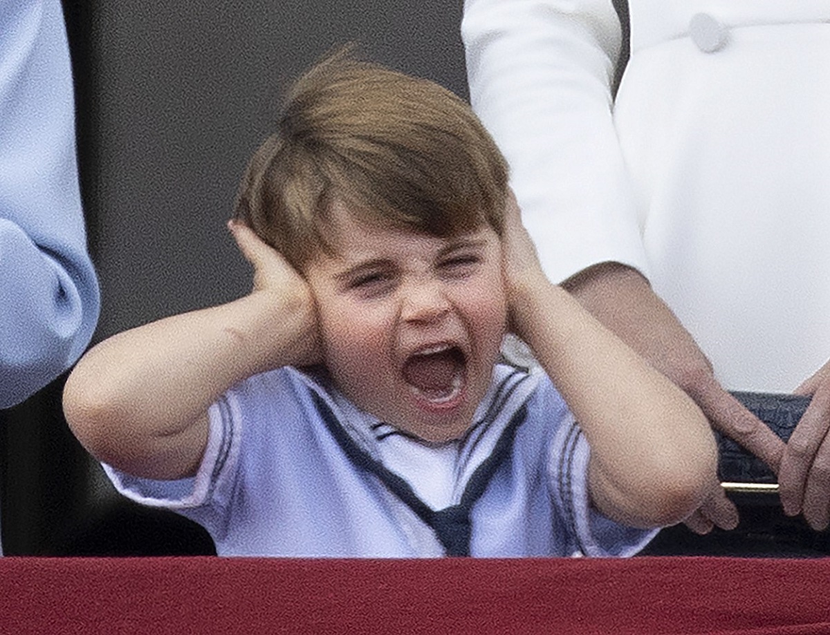 Prințul Louis în timp ce își acoperă urechile și țipă de la balconul Palatului Buckingham