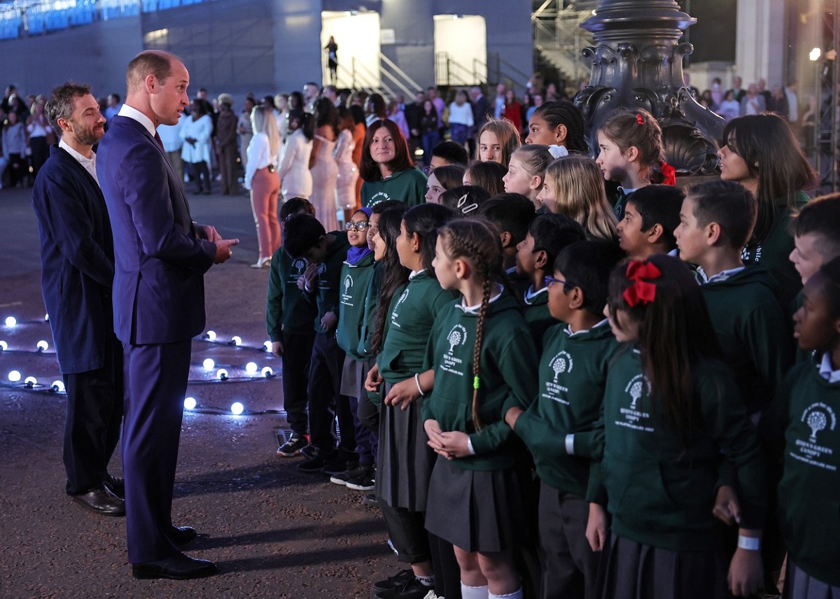 Prințul William la costum în fața unor copii în timp ce participă la ceremonia de aprindere a torțelor de la Palatul Buckingham