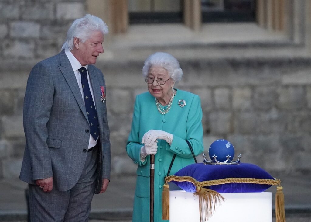 Regina Elisabeta în timp ce aprinde torțele de la Castelul Windsor