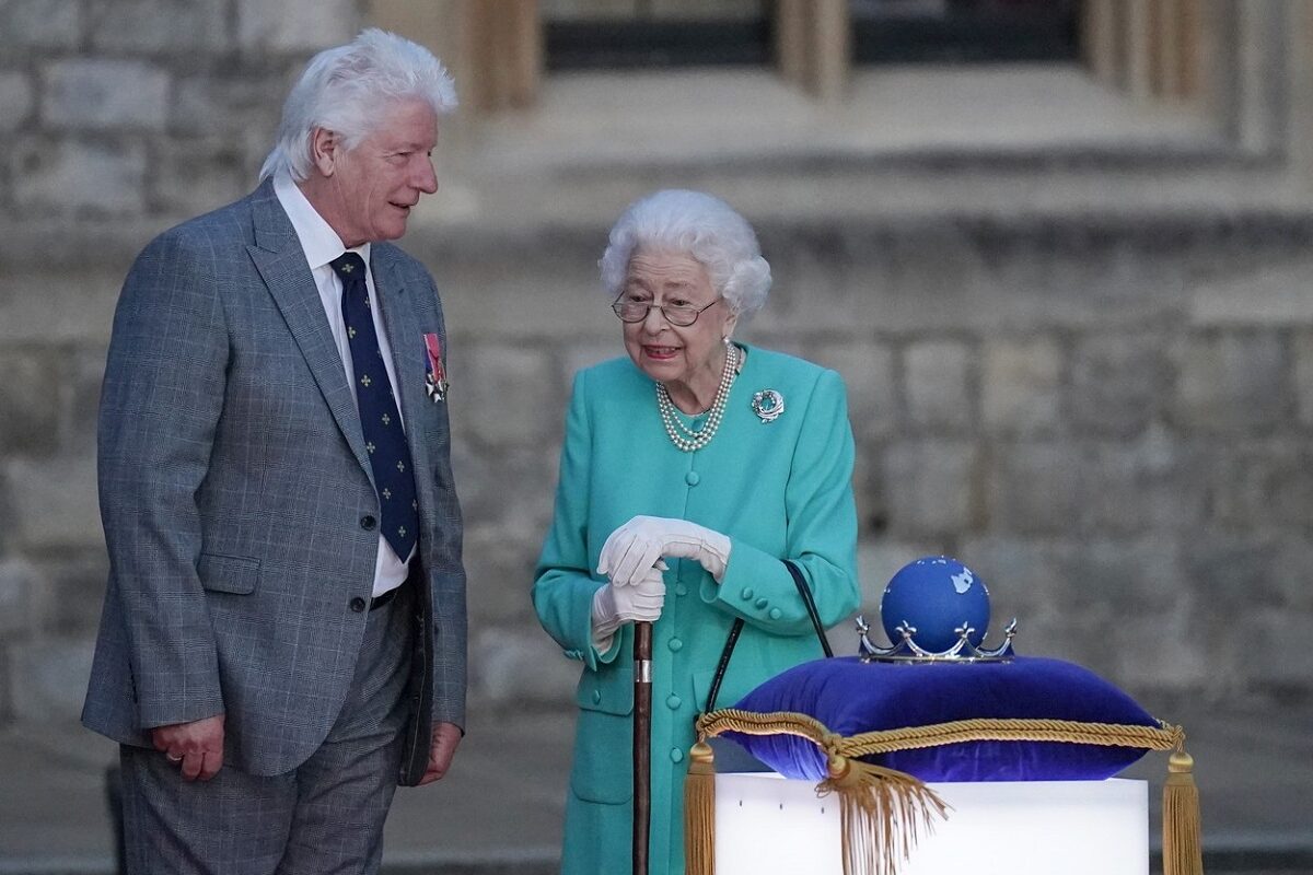 Regina Elisabeta în timp ce aprinde torțele de la Castelul Windsor