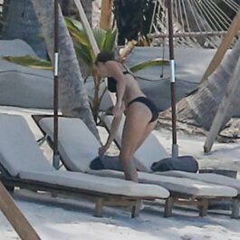 Taylor Swift, la plajă, într-un costum de baie negru, din două piese