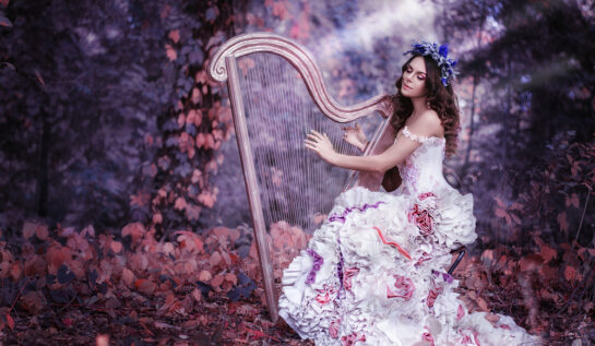Fată frumoasă cu părul închis la culoare cântă la harpă