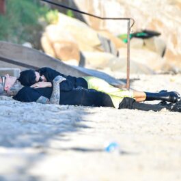 Kourtney Kardashian și Travis Barker în timp ce stau unul în brațele celuilalt pe o plajă din California