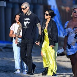 Kourtney Kardashian și Travis Barker în timp ce se plimbă de mână pe o plajă din Montecito