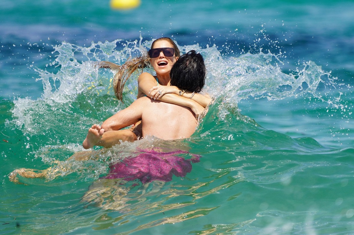 Sylvie Meis și Niclas Castello în timp ce stau îmbrățișați în valurile agitate ale mării