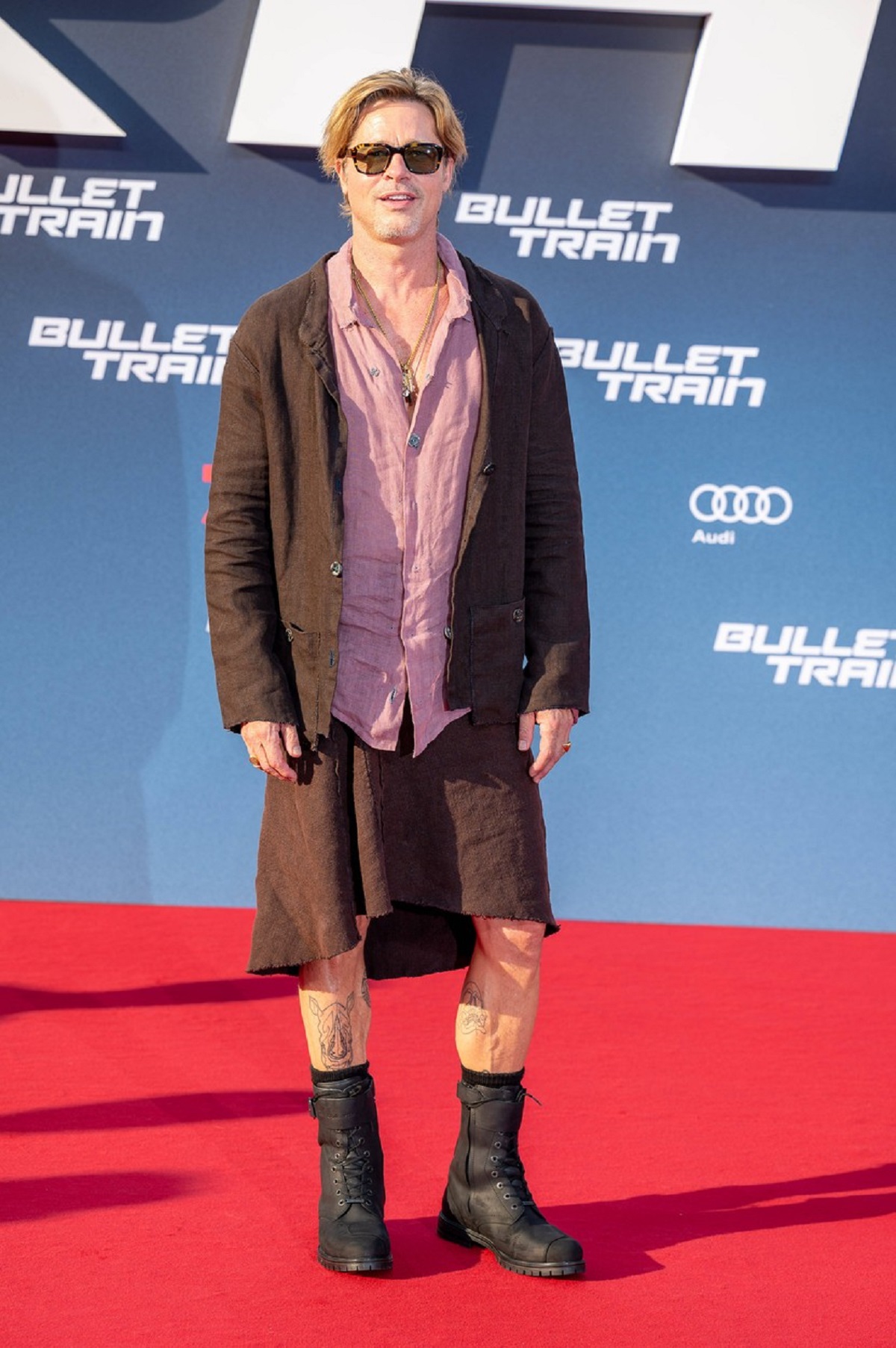 Brad Pitt îmbrăcat în fustă în timp ce pozează pe covorul roșu la premiera filmului Bullet Train din Berlin