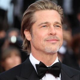 Brad Pitt îmbrăcat la costum cu papion în timp ce pozează pe covorul roșu la Festivalul de Film de la Cannes