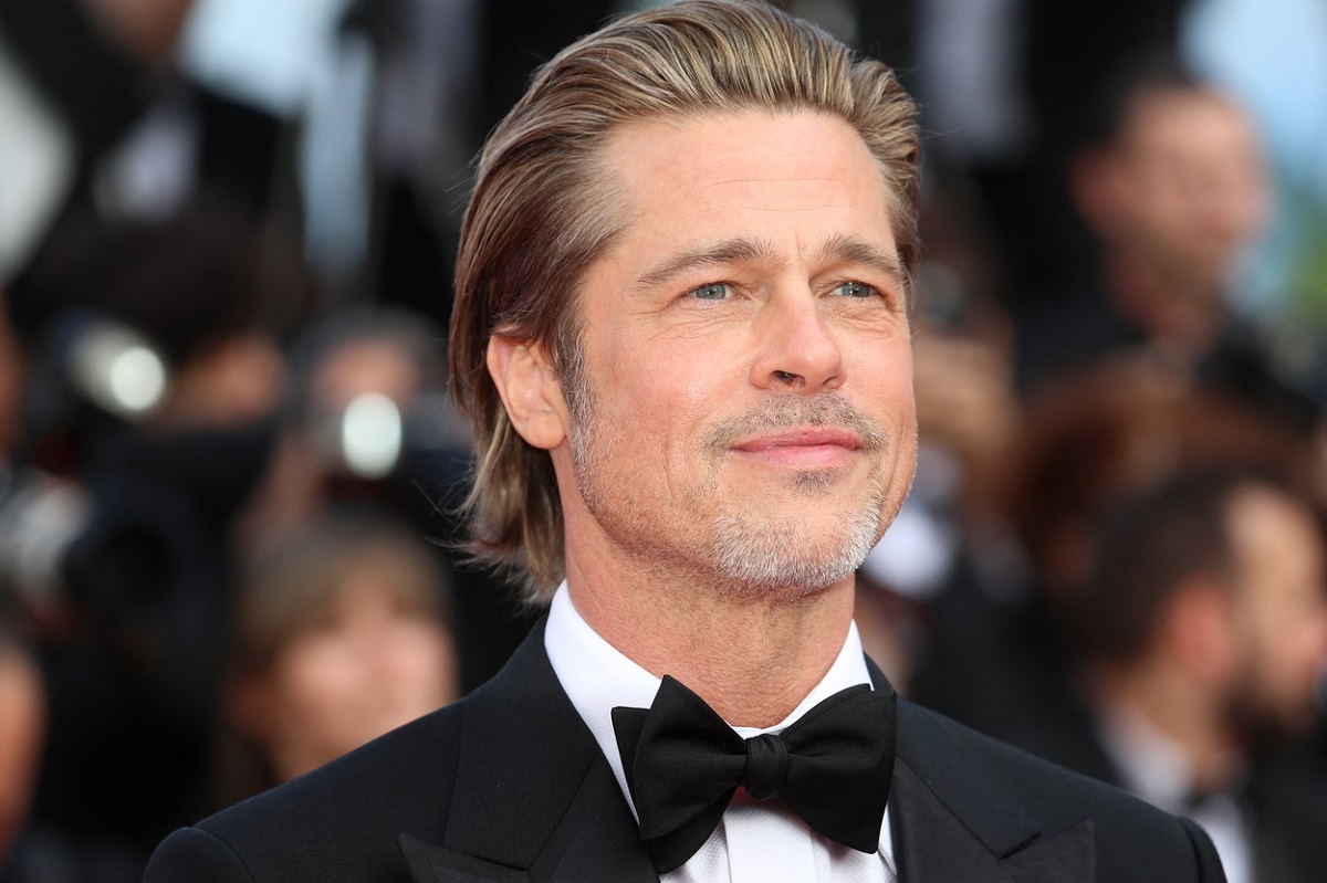Brad Pitt îmbrăcat la costum cu papion în timp ce pozează pe covorul roșu la Festivalul de Film de la Cannes