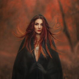 Fată frumoasă cu păr roșcat îmbrăcată în negru cu glugă