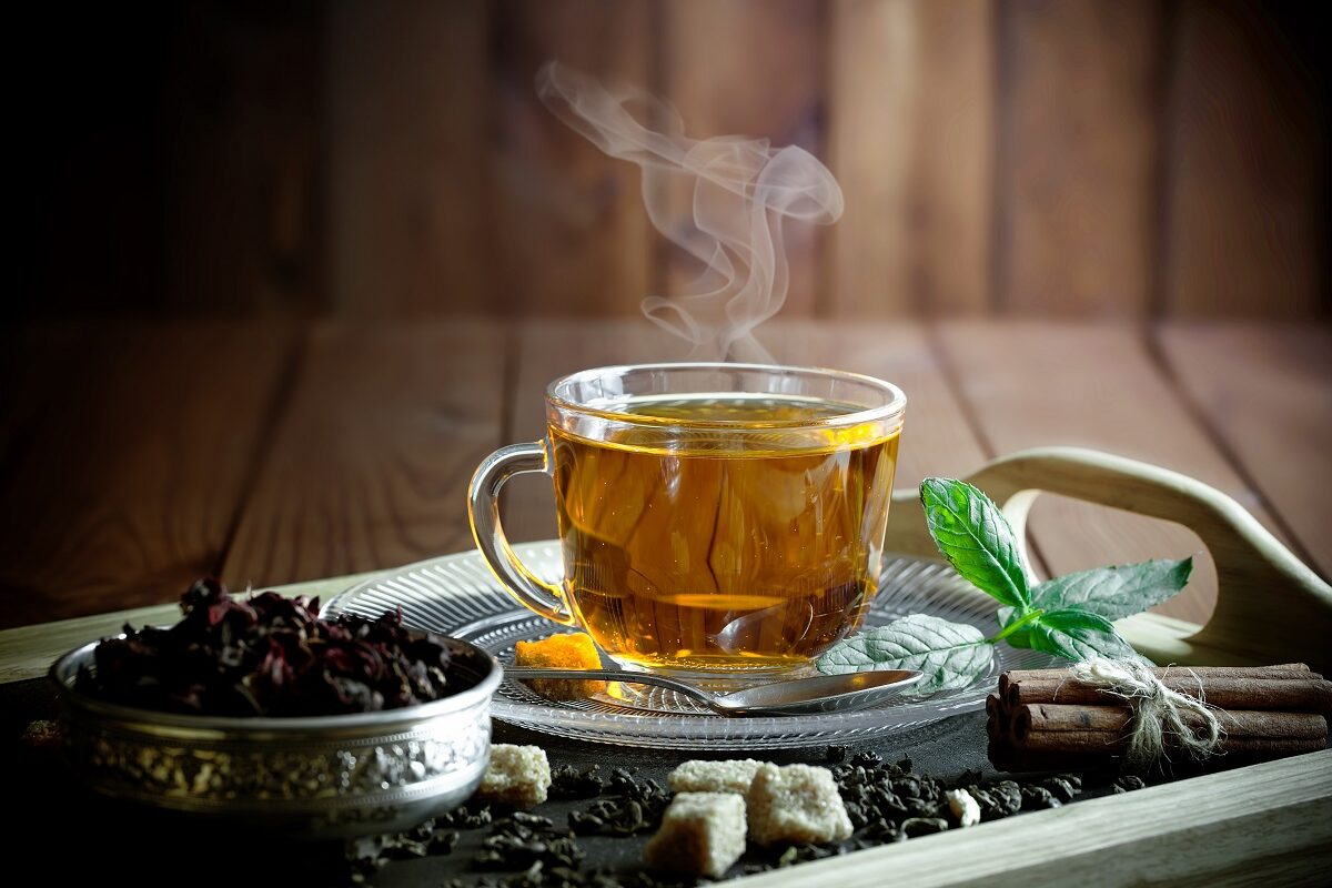 Un blat de lemn pe care se află o tavă cu o ceașcă de ceai care oferă un boost metabolismului