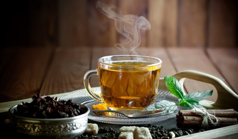 Un blat de lemn pe care se află o tavă cu o ceașcă de ceai care oferă un boost metabolismului