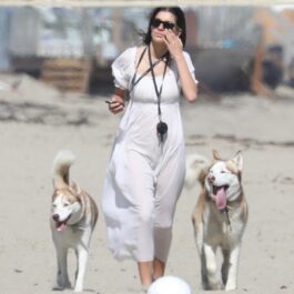 Camila Morrone alături de doi câini husky în timp ce se plimbă pe o plajă din Malibu