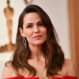 Jennifer Garner îmbrăcată într-o rohie roșie în timp ce se pozează pe covorul roșu la Gala Premiilor Oscar 2022