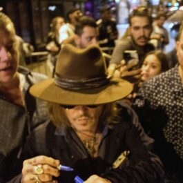 Johnny Depp semnând autpgrafe mulțimii din Paris