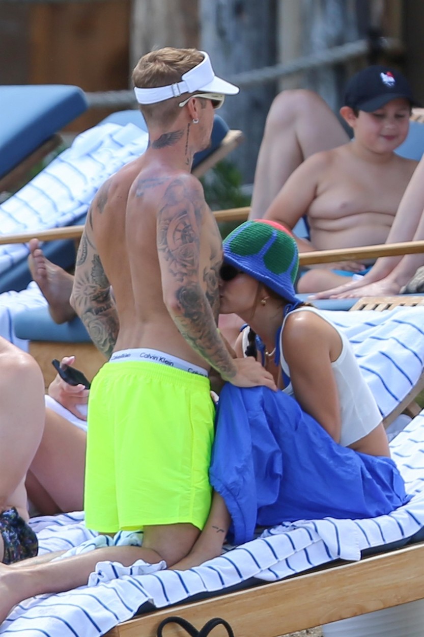 Hailey Bieber își sărută soțul pe abdomen, la plajă