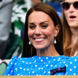 Kate Middleton îmbrăcată într-o rochie albastră cu buline în timp ce zâmbește la Wimbledon