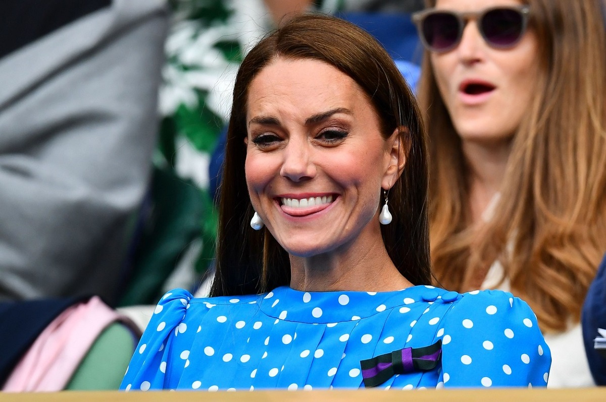Kate Middleton îmbrăcată într-o rochie albastră cu buline în timp ce zâmbește la Wimbledon